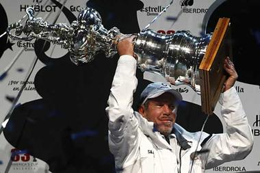 BMW Oracle owner Larry Ellison lifts up the trophy after winning the 33rd America's Cup in Valencia, Sunday.  Heino Kalis / Reuters