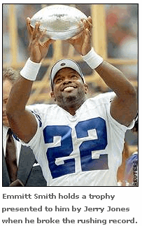 Photo: Emmitt Smith holds a trophy presented to him by Jerry Jones when he broke the rushing record