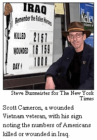 Photo: Scott Cameron, a wounded Vietnam veteran, with his sign noting the numbers of Americans killed or wounded in Iraq.