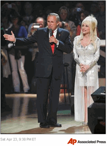 Photo Secretary of Defense Donald Rumsfeld, left, thanks the audience for their support of the troops as he takes the stage of the Grand Ole Opry with host Dolly Parton in Nashville, Tenn., Saturday, April 23, 2005. The Opry is celebrating its 80th year of entertaining. (AP Photo/John Russell)