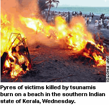 Photo: Pyres of victims killed by tsunamis burn on a beach in the southern Indian state of Kerala, Wednesday. 