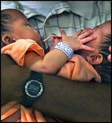 Jade and Erin Buckles are held by their father Kevin before the operation. (Carol Guzy/Post)