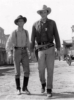Photo: This 1956 file photo shows actors Dennis Weaver, left, as the slow-witted deputy Chester and James Arness as Marshall Matt Dillon, are shown in a scene from CBS' TV classic western 'Gunsmoke' in 1956. Weaver died of complications from cancer on Friday, Feb. 24, 2006, at his home in Ridgway, in southwestern Colorado, publicist Julian Myers said. The actor was 81. (AP Photo/file)