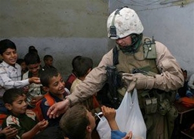 Staff Sergeant Raymond Plouhar This photo released by the U.S. Marine Corps shows Staff Sgt. Raymond Plouhar handing candy to students at the Al Nabatiya Elementary School, May 9, 2006, near Fallujah, Iraq. Plouhar, 30, of Lake Orion, Mich., who was featured in Michael Moore's antiwar documentary, 'Fahrenheit 9/11,' was killed on June 26, 2006, by a roadside bomb in Anbar province in his second tour of duty in Iraq. (AP Photo/U.S. Marine Corps)