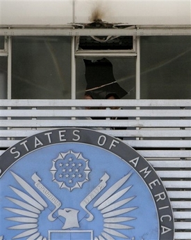 U.S. Embassy in Athens, Greece Hit by Terrorists Police anti-terrorist officers investigate the area behind the banner emblem of the US Embassy in Athens on Friday, Jan. 12, 2007. An anti-tank shell was fired at the U.S. embassy early Friday, striking the front of the building but causing no injuries. Greece's public order minister said the blast was 'very likely' an act of terrorism by a domestic group, raising fears of resurgent violence by far-left Greek militants. (AP Photo/Thanassis Stavrakis)