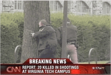 Virginia Tech Shooting Photo Law enforcement officers take cover behind a tree during the investigation of a shooting at the Virginia Tech campus in Blacksburg, Va. Gunfire erupted in a dorm and classroom at Virginia Tech on Monday, killing 22 people, the police chief said. The gunman was killed. (AP Photo/WDBJ via CNN)