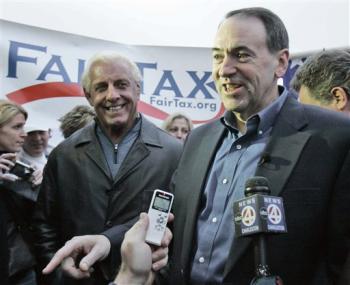 Mike Huckabee - False Conservative? Republican presidential hopeful, former Arkansas Gov. Mike Huckabee, right, talks with reporters as Rick Flair campaigns outside Williams Brice Stadium before the Clemson-South Carolina football game Saturday, Nov. 24, 2007, in Columbia, S.C. (AP Photo/Mary Ann Chastain)