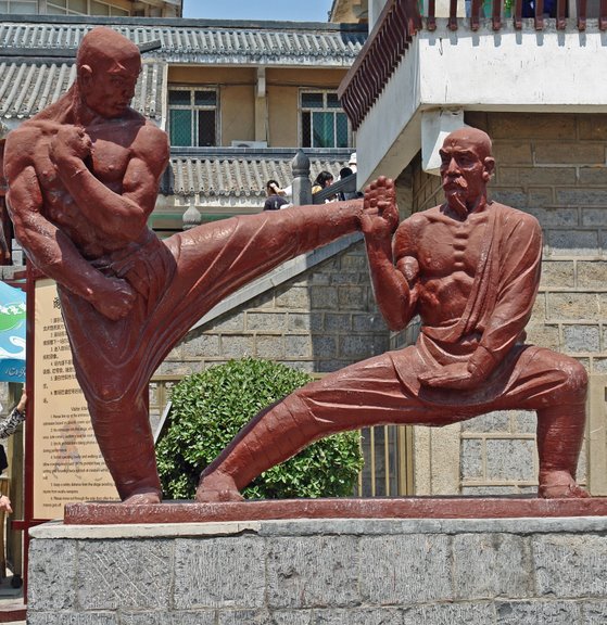 Shaolin Monks Bow Out of Kung Fu Tournament China.Henan Province.Shaolinsi.Shaolin Temple: Statue of Monks Practicing Kung Fu