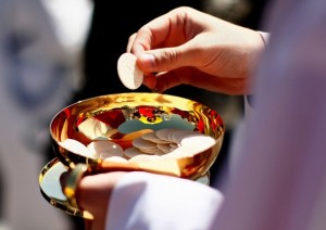 WASHINGTON - APRIL 17:  A priest holds a Holy Communion wafer as Pope Benedict XVI celebrates Mass at Nationals Park April 17, 2008 in Washington, DC. Today is Pope Benedict XVI's third day of his visit to the United States.  (Photo by Win McNamee/Getty Images)