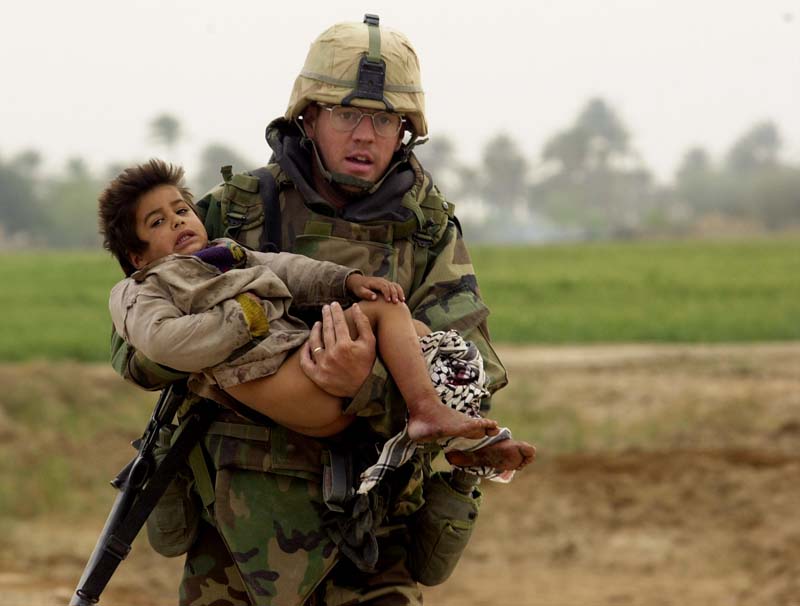 Pfc. Joe Dwyer carried a young Iraqi boy who was injured during a heavy battle between the U.S. Army's 7th Cavalry Regiment and Iraqi forces near the village of Al Faysaliyah, Iraq, on March 25, 2003. Dwyer died of an apparent overdose at his home in North Carolina on June 29, 2008.