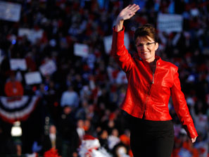 Sarah Palin, in a red leather jacket, waves as she steps on stage before a crowd at a baseball field in Grand Junction, Colo., on Monday.