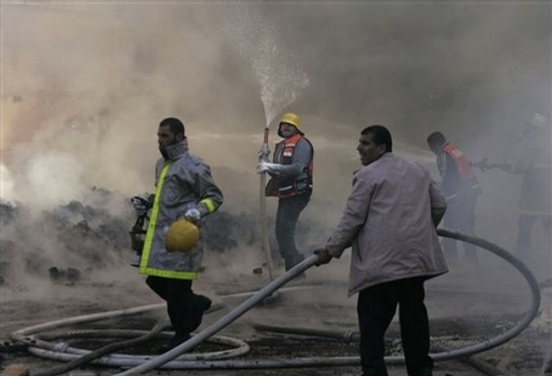 United Nations workers and Palestinian firefighters work to try and put out a fire and save bags of food aid at the United Nations headquarters after it was hit in Israeli bombardment in Gaza City, Thursday, Jan. 15, 2009. Israeli forces shelled the United Nations headquarters in the Gaza Strip on Thursday, setting the compound on fire as U.N. chief Ban Ki-moon was in the area on a mission to end Israel's devastating offensive against the territory's Hamas rulers. Ban expressed "outrage" over the incident.(AP Photo/Hatem Moussa)