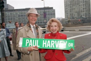 In this Nov. 16, 1988 file photo, radio commentator Paul Harvey and his wife, Lynne, hold a street sign bearing his name in Chicago. A one-block stretch of East Wacker Dr. is changed to Paul Harvey Dr. in honor of the well-known broadcaster. ABC Radio Network says broadcasting pioneer Paul Harvey has died at the age of 90. Network spokesman Louis Adams says Harvey died Saturday Feb. 28, 2009 at his winter home in Phoenix, surrounded by family.  (AP Photo/Charles Bennett, File)