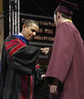 President Barack Obama fist bumps an unidentified graduate at the Arizona State University commencement ceremony at Sun Devil Stadium in Tempe, Ariz., Thursday, May 14, 2009. (AP Photo/Charles Dharapak)