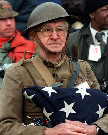 Joseph Ambrose, an 86-year-old World War I veteran, attends the dedication day parade for the Vietnam Veterans Memorial in 1982, holding the flag that covered the casket of his son, who had been killed in the Korean War.