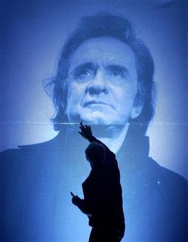 A stage hand at the Ryman Auditorium puts the final touchs on a large photo of the late country music legend Johnny Cash, before the Cash tribute concert in Nashville, Tennessee, late November 10, 2003. REUTERS/John Sommers II JPSII/GN