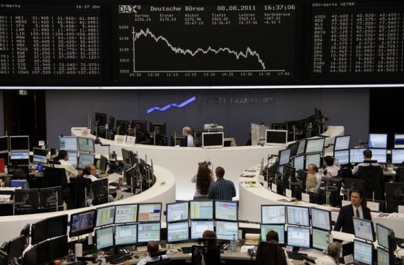 Traders work in front of the DAX index board at Frankfurt's stock exchange